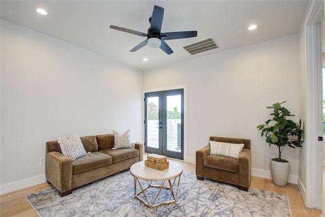 living room with hardwood / wood-style flooring, ceiling fan, and french doors