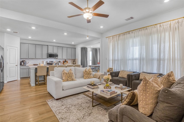 living room featuring ceiling fan and light wood-type flooring