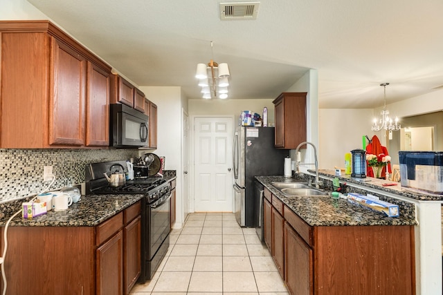 kitchen featuring tasteful backsplash, decorative light fixtures, a chandelier, and black appliances