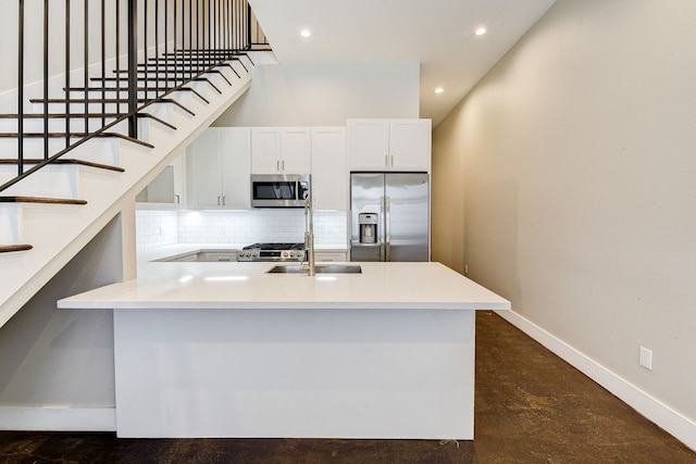 kitchen featuring sink, tasteful backsplash, a towering ceiling, stainless steel appliances, and white cabinets