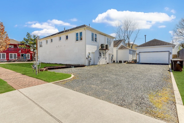 view of front of property with a garage, an outdoor structure, and a front lawn