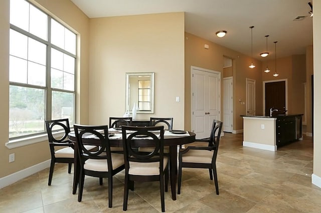 dining room with sink, a healthy amount of sunlight, and a high ceiling