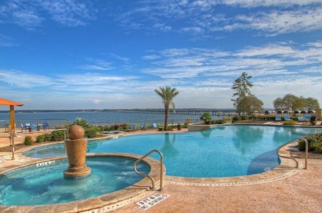 view of pool featuring a hot tub and a water view