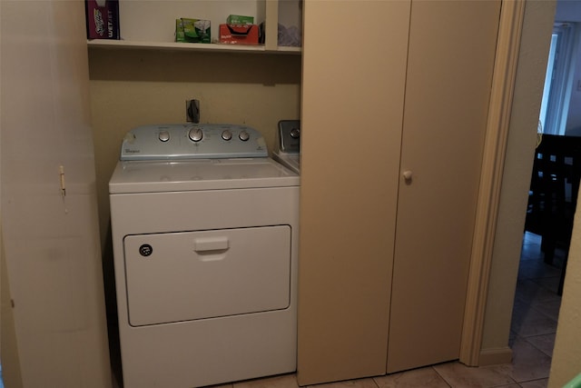 laundry area with light tile patterned floors and washing machine and clothes dryer