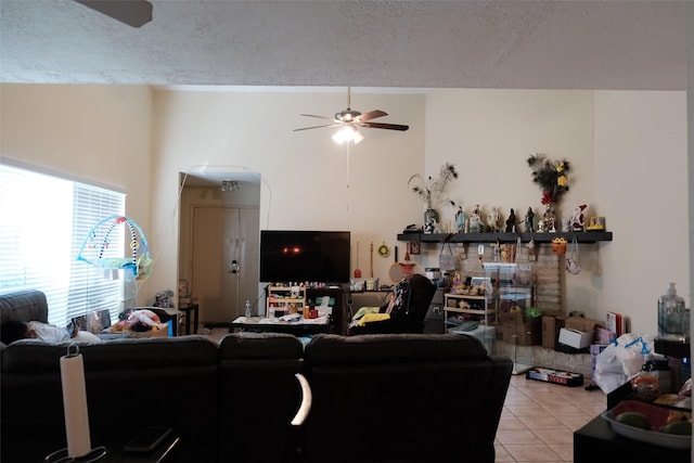 tiled living room featuring ceiling fan and a textured ceiling