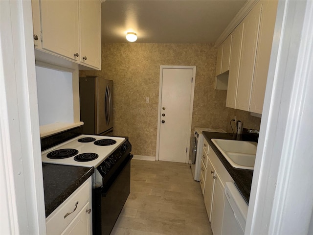 kitchen with white cabinetry, sink, stainless steel fridge, white dishwasher, and black range with electric cooktop