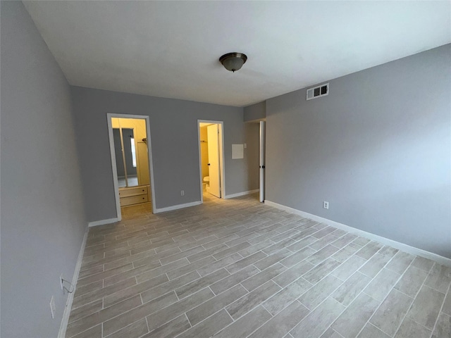 unfurnished bedroom with light wood-type flooring and ensuite bath