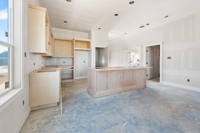 kitchen featuring light brown cabinetry, a center island, and a wealth of natural light