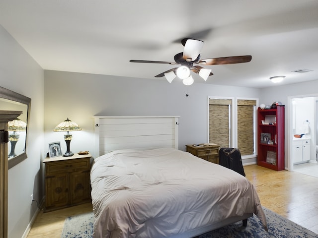 bedroom with ceiling fan, connected bathroom, and light wood-type flooring