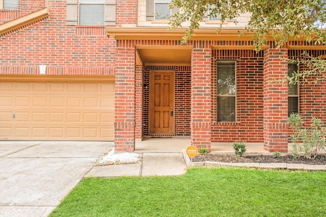 view of exterior entry with driveway and brick siding