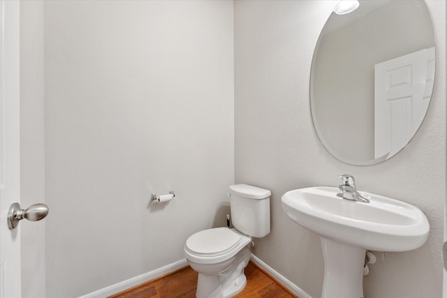 bathroom featuring baseboards, toilet, and wood finished floors