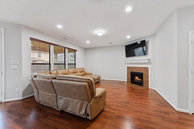 living area with recessed lighting, a fireplace, wood finished floors, and baseboards