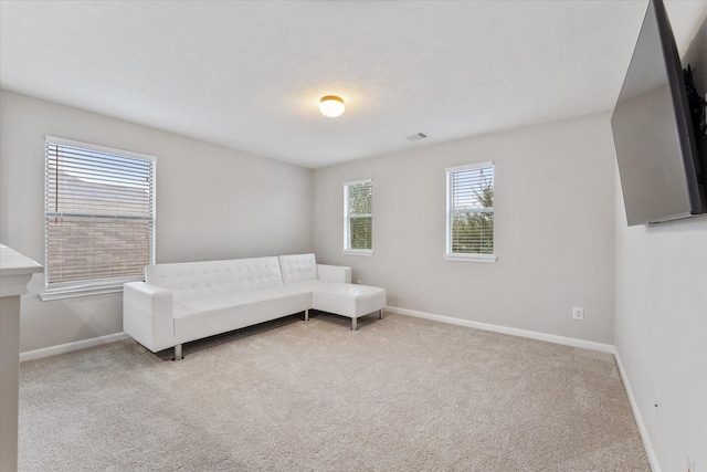 unfurnished room with light colored carpet, visible vents, and baseboards