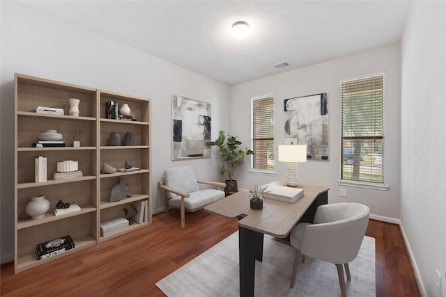 home office with dark wood-type flooring, visible vents, and baseboards