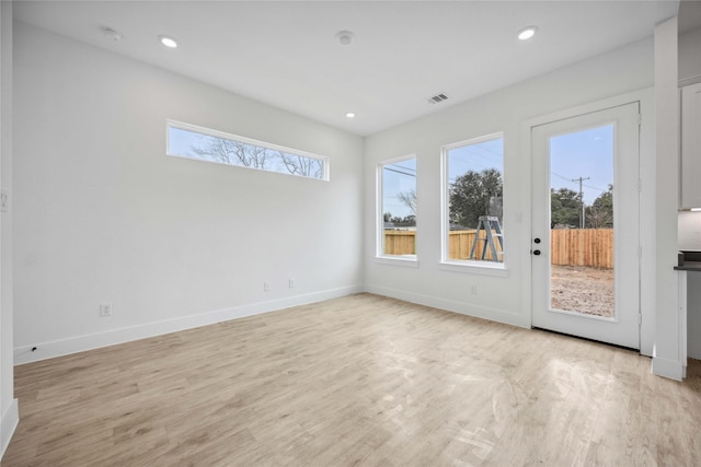 empty room with plenty of natural light and light wood-type flooring