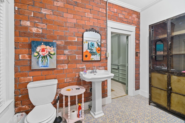 bathroom featuring tile patterned flooring, ornamental molding, brick wall, and toilet