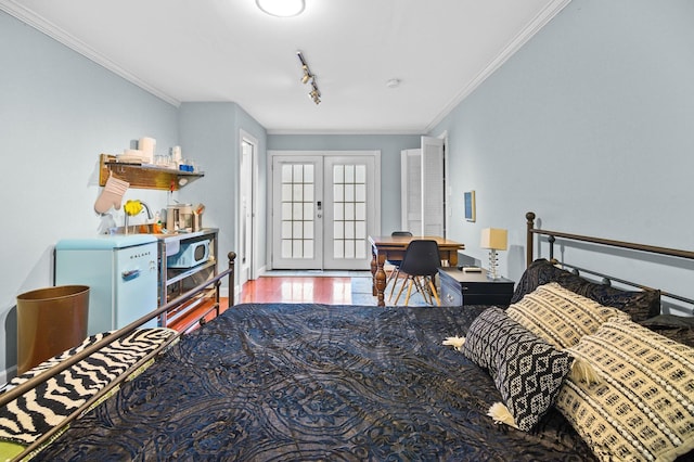 bedroom featuring french doors, fridge, track lighting, ornamental molding, and hardwood / wood-style floors