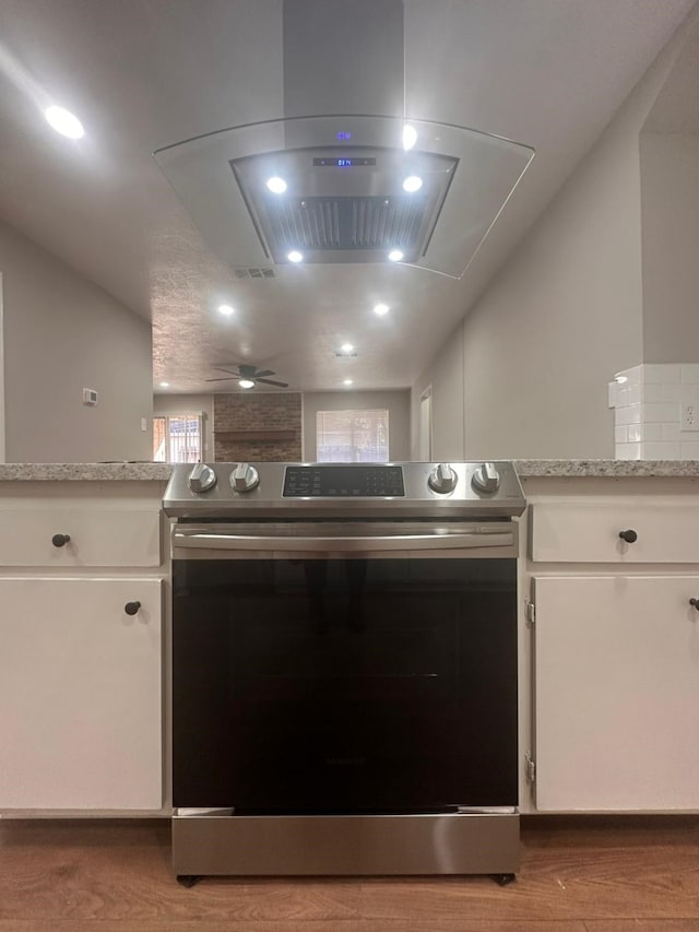 kitchen featuring white cabinetry, stainless steel electric range, light wood finished floors, and island range hood