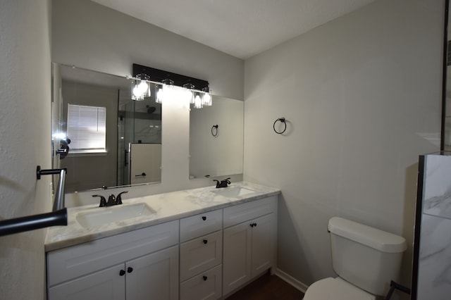 full bath with a sink, toilet, a stall shower, and double vanity