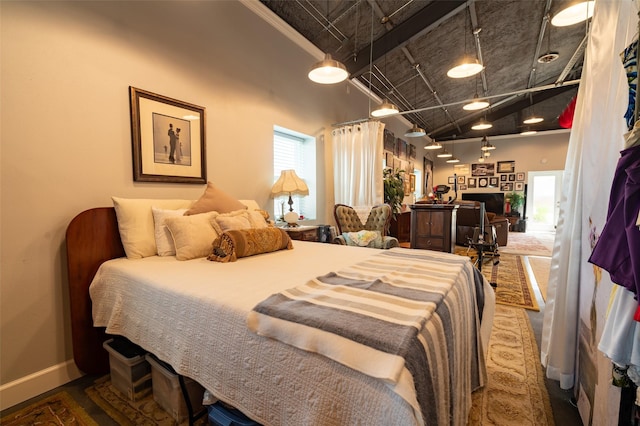 bedroom featuring a fireplace and a high ceiling