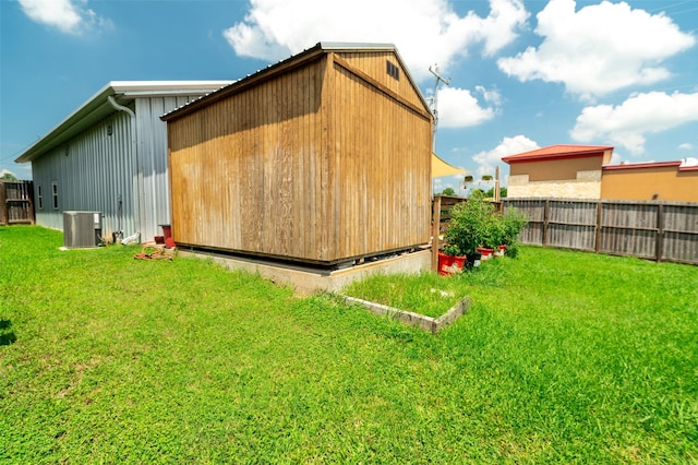 view of side of property with central AC and a lawn