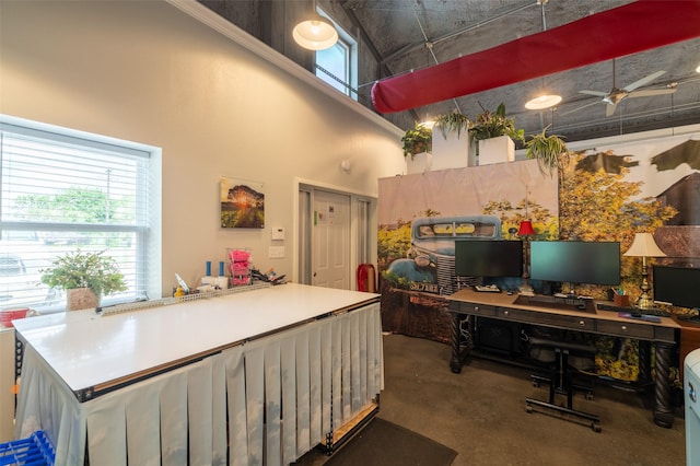 office with ceiling fan and a towering ceiling