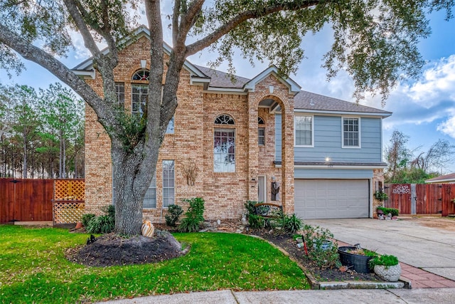 traditional-style home featuring an attached garage, fence, concrete driveway, and brick siding