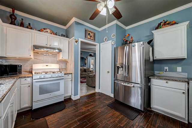 kitchen with appliances with stainless steel finishes, ornamental molding, dark wood-style flooring, under cabinet range hood, and white cabinetry