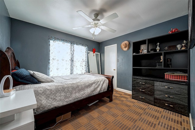 carpeted bedroom with ceiling fan and baseboards