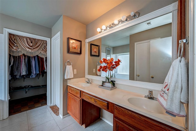 bathroom featuring tile patterned flooring, a sink, and double vanity