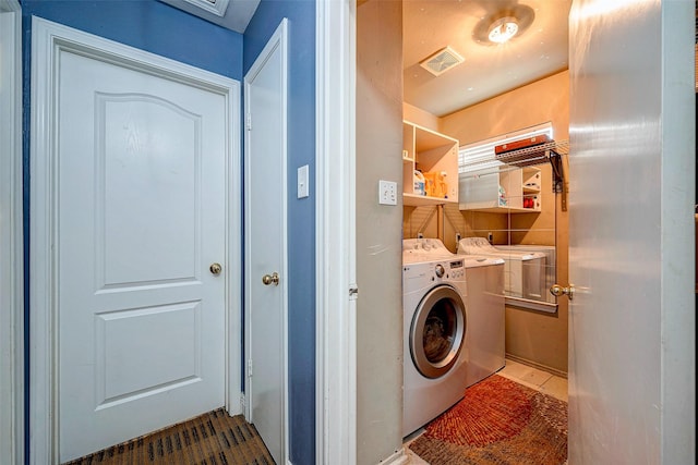 washroom featuring laundry area, visible vents, and washer and dryer