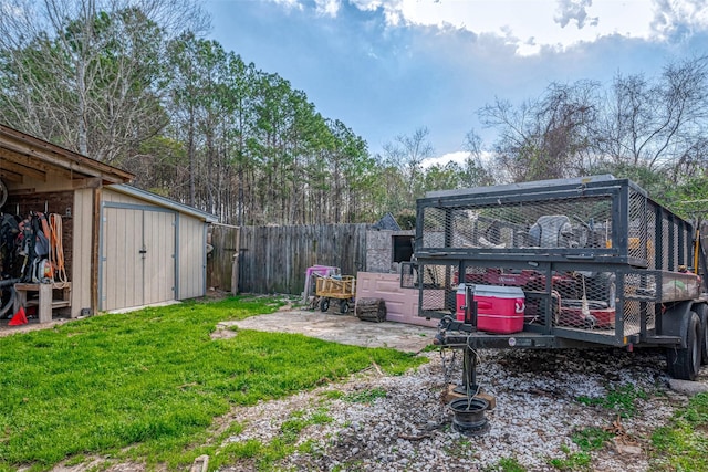 view of yard featuring an outbuilding, fence, and a storage unit