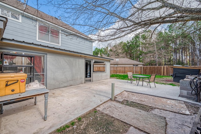 view of patio / terrace featuring a jacuzzi and fence