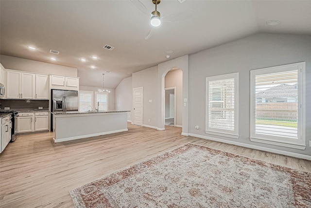 kitchen featuring white cabinetry, lofted ceiling, a center island, stainless steel appliances, and light wood-type flooring