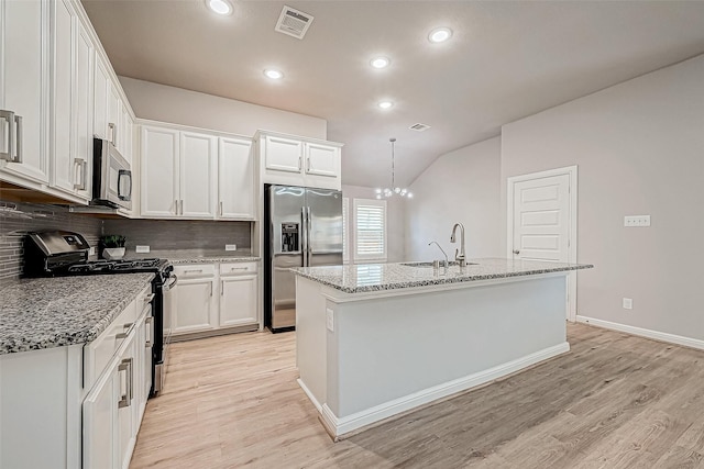 kitchen featuring appliances with stainless steel finishes, an island with sink, and white cabinets