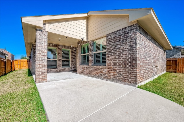 rear view of house with a yard and a patio