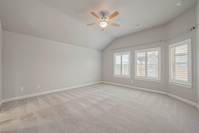 carpeted empty room with vaulted ceiling and ceiling fan