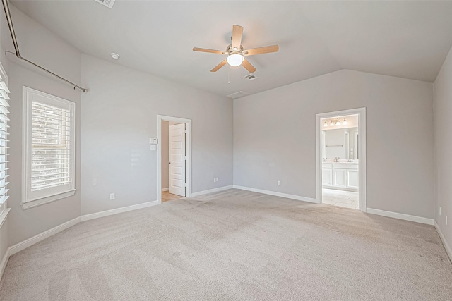 spare room featuring ceiling fan, lofted ceiling, and light carpet