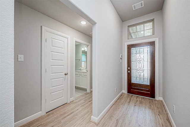 foyer entrance with sink and light hardwood / wood-style floors