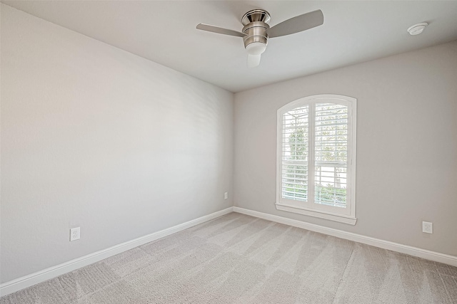 empty room featuring ceiling fan and carpet