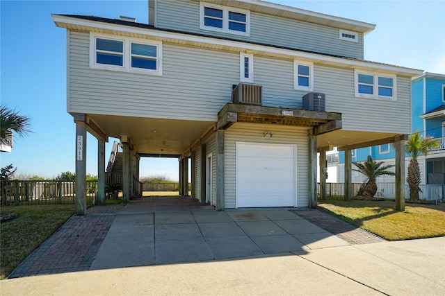 view of front of home featuring central AC unit, a garage, and a carport