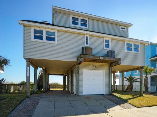 23911 Termini San Luis Pass Rd, Galveston, TX 77554 - back of house with central AC, stairs, a carport, concrete driveway, and a garage