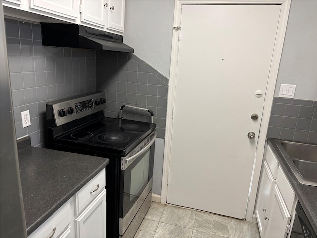 kitchen with decorative backsplash, sink, white cabinets, and electric stove