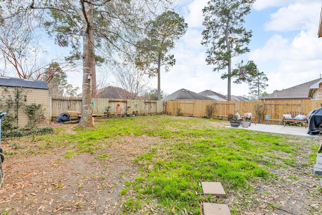 view of yard featuring a storage shed and a patio