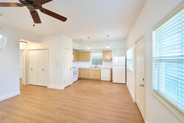 kitchen featuring light brown cabinetry, sink, hanging light fixtures, white appliances, and light hardwood / wood-style floors