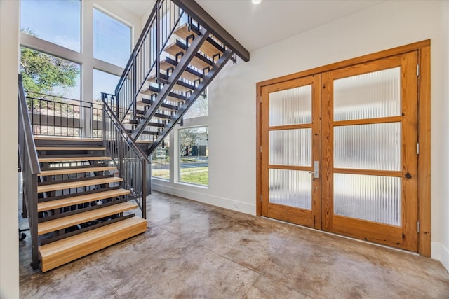 staircase with french doors and concrete flooring