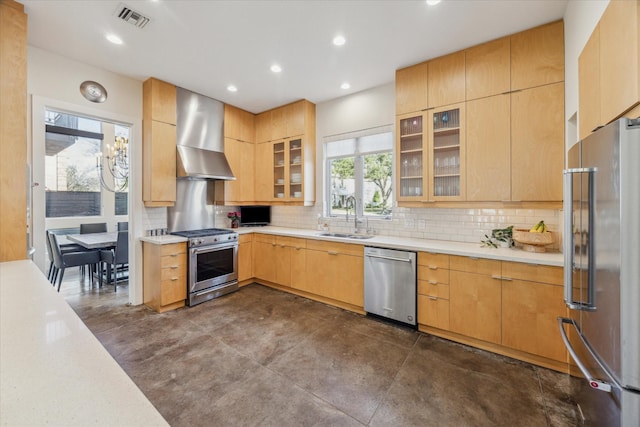 kitchen featuring sink, backsplash, light brown cabinets, stainless steel appliances, and wall chimney range hood