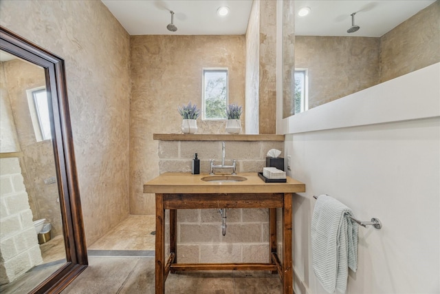 bathroom featuring sink, track lighting, and a shower