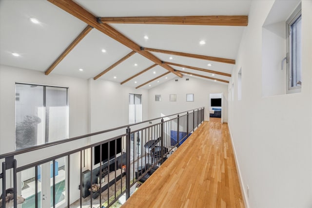 hallway featuring beamed ceiling, wood-type flooring, and high vaulted ceiling