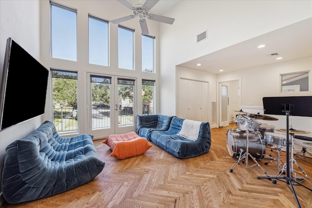 living room with french doors, light parquet flooring, and a high ceiling